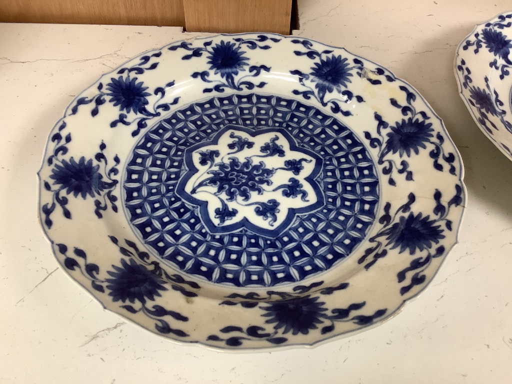 A pair of Chinese blue and white porcelain plates, Kangxi mark and period, with shaped borders and floral motifs, diameter 20cm